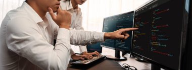 Yazılım geliştirme ekibi ofiste birlikte çalışıyor, bilgisayar ekranında betik görüntülemesi kodluyor. Teknoloji geliştirici şirketinde çalışan programcı ve yazılım mühendisi. Önde.