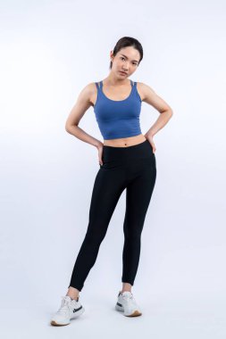 Spor giyim portresindeki tüm vücut Asyalı kadın gülümsüyor ve neşeli bir jest yapıyor. Çekici bir kızla egzersiz yapmak sağlıklı yaşam tarzını sürdürmeye yöneliktir. İzole edilmiş arka plan Vigorous