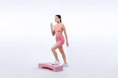 Çalışkan, enerjik bir kadın atölyede egzersiz yapıyor. Kardiyo aerobik hareketleriyle izole bir arka plan. Genç atletik Asyalı kadın mahareti ve dayanıklılık eğitimi konsepti.