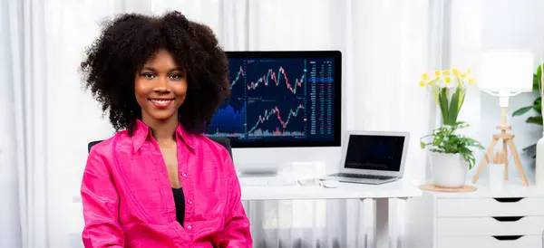 分析性的年轻非洲裔美国女商人 一个成功的证券交易专家 与在屏幕上显示营销趋势分析的动态数据图相对照 节衣店 — 图库照片