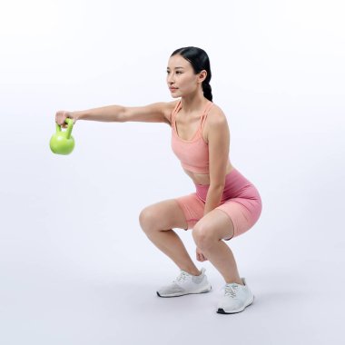 Dinç, enerjik bir kadın izole edilmiş arka planda ağırlık kaldırma egzersizi yapıyor. Genç atletik Asyalı kadın dayanıklılığı ve dayanıklılık eğitimi rutin vücut egzersizi..