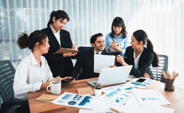 Ofis masasındaki finansal veri raporlarını analiz eden çeşitli bir grup iş analisti. Stratejik pazarlama planlaması için iş istihbarat analizine göre grafikler ve grafikler.