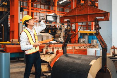 Makine operatörü çelik üretim makinelerini ustalıkla çalıştırıyor, metal fabrikasındaki ağır inşaat mühendisliği malzemeleri için silindir rulo çelik üretiyor. Örnek gösteriliyor