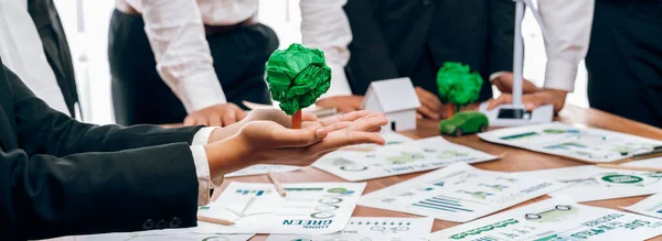 Green eco-friendly business people with environmental responsibility meeting on reforestation and alternative sustainable energy utilization. Businessman hold paper tree in meeting room.Trailblazing