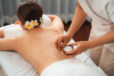 Lüks spa salonlarında sıcak mum ışığında cilt bakımı yaptıran kadın müşteri. Sağlık Spa vücut fırçasında tuz temizleme güzellik tedavisi. Sessiz.