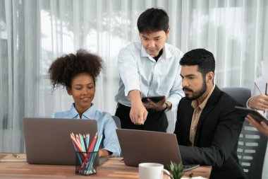 Mutlu iş adamları birlikte çalışır, şirket ofisinde tartışırlar. Profesyonel ve çeşitlilik takım çalışması iş planını bilgisayarda tartışır. Modern çok kültürlü ofis çalışanı. Uyum