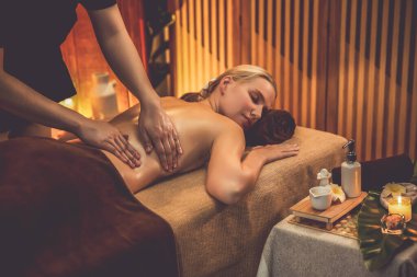 Beyaz kadın müşteri stres önleyici spa masajının keyfini çıkarıyor ve lüks otel ya da otelde sıcak mum ışığında güzellik teniyle eğleniyor. Sessiz.