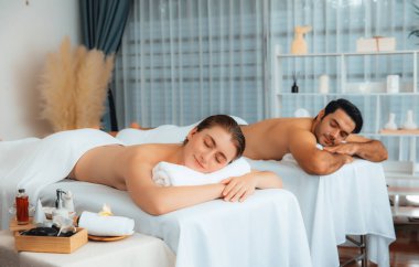 Kafkas çift müşterisi stres önleyici spa masajının keyfini çıkarıyor ve lüks otel veya oteldeki gündüz açık hava ortamında güzellik teniyle eğleniyor. Sessiz.