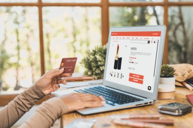 İnternet pazarından alışveriş yapan kadın modern yaşam tarzı için satış malzemeleri arıyor ve önemli siber güvenlik yazılımları tarafından korunan cüzdandan çevrimiçi ödeme için kredi kartı kullanıyor