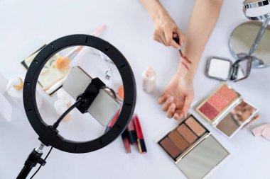 Güzellik blogcusunun ya da nüfuzlu kişinin üst görünümü çevrimiçi canlı yayın platformunda sosyal medya pazarlamasını ya da öğretim elemanlarını görüntüler.