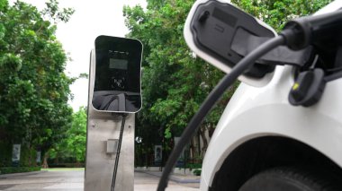 Elektrikli araba parkı ve şarj istasyonunun yanında şarj edilen enerji konseptinin sürdürülebilirliği. Çevresel koruma için yenilenebilir enerji tarafından kullanılan elektrikli araç.
