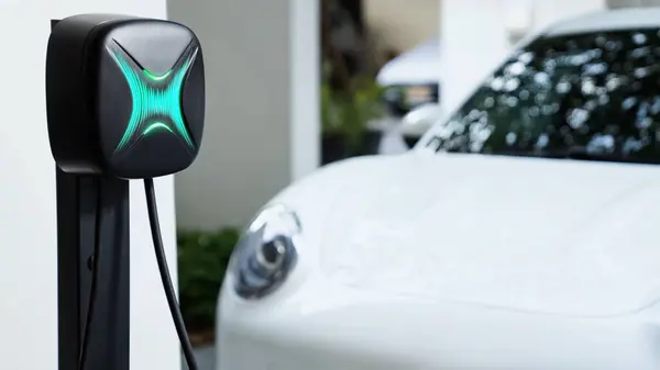 Electric car plugged in with home charging station to recharge battery by EV charger cable. Future innovative EV car and energy sustainability. Smart and futuristic home energy infrastructure. Peruse