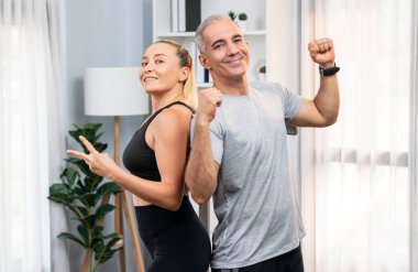 Sportif ve sportif son sınıf çifti portresi. Spor kıyafetleri içinde. Emeklilikten sonra sağlıklı vücut yaşam tarzına sahip ev egzersizi konsepti olarak mücadele duruşunu aştıktan sonra veya başarılı bir şekilde kutlandıktan sonra. Etki