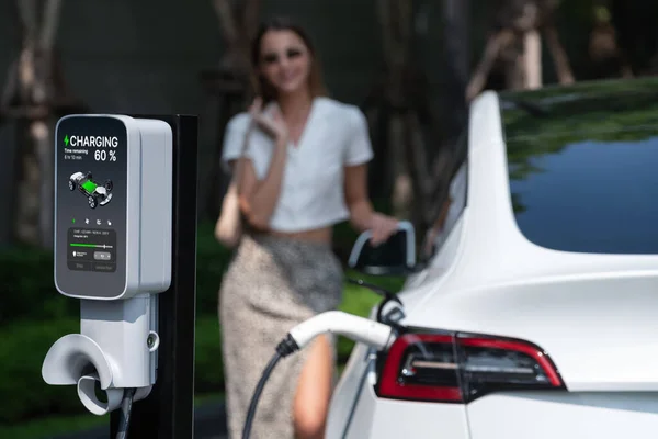 Молода Жінка Подорожує Електричним Автомобілем Який Заряджається Зеленому Стійкому Міському — стокове фото