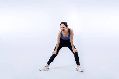 Spor giyim portresindeki tüm vücut Asyalı kadın gülümsüyor ve neşeli bir jest yapıyor. Çekici bir kızla egzersiz yapmak sağlıklı yaşam tarzını sürdürmeye yöneliktir. İzole edilmiş arka plan Vigorous