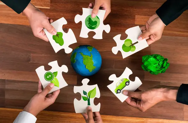 Top view cohesive group of business people holding eco icon jigsaw puzzle pieces around globe Earth as eco corporate responsibility for community and sustainable solution for greener Earth. Quaint
