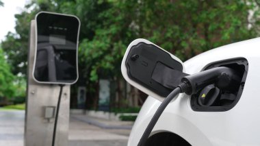 Elektrikli araba parkı ve şarj istasyonunun yanında şarj edilen enerji konseptinin sürdürülebilirliği. Çevresel koruma için yenilenebilir enerji tarafından kullanılan elektrikli araç.