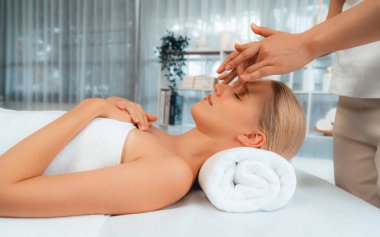 Kafkasyalı kadın stres önleyici kafa masajından ve lüks tatil beldesi ya da otel spa salonundaki modern ışık ortamında yüz güzelliği eğlencelerini şımartmaktan hoşlanıyor. Sessiz.