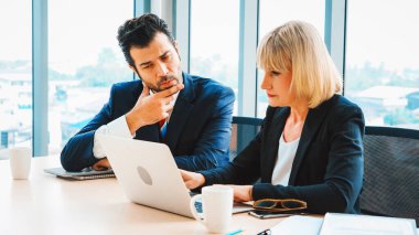 İki iş adamı toplantı odasında proje stratejisi hakkında konuşuyor. İş adamı, iş yerinde iş arkadaşlarıyla proje planlamasını tartışırken aynı zamanda mali raporla ilgili sohbet ve tavsiyelerde bulunuyor. Jivy