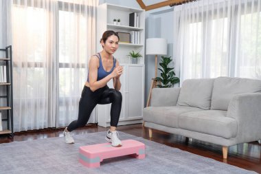 Enerjik bir kadın evde egzersiz yapıyor, kardiyo aerobik egzersizi yapıyor. Genç atletik Asyalı kadın mahareti ve dayanıklılık antrenmanı ev ödevi rutin konsepti olarak..