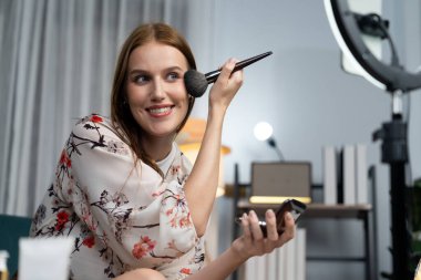 Kadın Etkilenen Vlog video görüntülerini sosyal medya ya da blog 'da en üst düzeyde yayınlıyor. Kozmetik stüdyosu ışıklandırmalı mutlu genç kız çevrimiçi pazarlama oturumu yayını için..