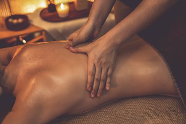 Yakından kadın müşteri strese karşı spa masajını rahatlatıyor ve lüks otel ya da otelde sıcak mum ışığında güzellik teniyle eğleniyor. Sessiz.