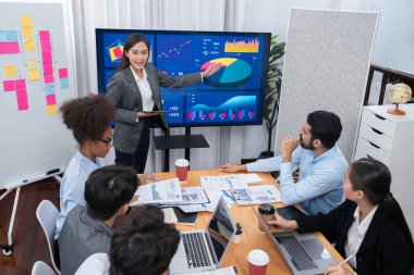 Genç Asyalı iş kadını modern toplantıda TV ekranında veri analizi paneli sunuyor. Bir grup iş adamıyla konferans odasında iş sunumu. Uyum