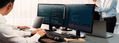 Yazılım geliştirme ekibi ofiste birlikte çalışıyor, bilgisayar ekranında betik görüntülemesi kodluyor. Teknoloji geliştirici şirketinde çalışan programcı ve yazılım mühendisi. Önde.