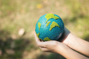 Dünya gezegenini ESG ilkesi ve çevre dostu enerjisiyle daha parlak bir gelecek için Dünya günü olarak el ele tutuşan genç çocuklar. Döngü