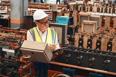 Fabrika mühendisi endüstriyel çelik oluşum makinesini teftiş ediyor. Metal makine mühendisliği denetim denetçisi olarak liderliği gösteriyor..