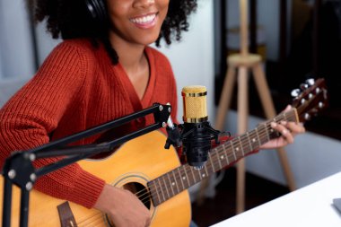 Güzel Afrikalı kadın etkilerinin portre sunucusu kanalı yayında gitar çalarak şarkı söylüyor. Canlı sosyal medyada müzik blogcusu zamanı. Ses yaratıcısı kavramı. Tatlandırıcı.