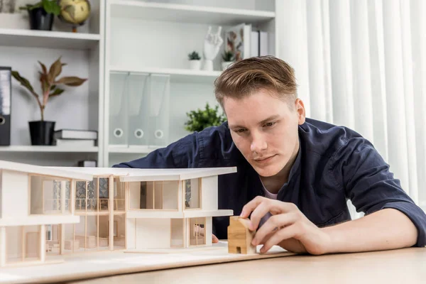 アーキテクトデザイナーは エレガントな家モデルを研究し テーブル上の建設計画を改善するための構造設計をレビューします 建築デザインにおける創造性と革新 イタレーション — ストック写真