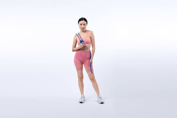 Young energetic asian woman in sportswear with jumping or skipping robe posing portrait in studio shot on isolated background. Cardio exercise tool and healthy body care lifestyle. Vigorous