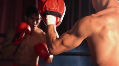 Asyalı ve Kafkasyalı Muay Thai boksörü boks antrenmanında boks antrenmanında boks antrenörüne yumruk atma, Muay Thai boks tekniği ve becerilerini sergileme. Impetus