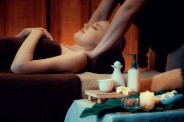 Aromaterapi masajı ambiyansı ya da spa salonu kompozisyon düzeneği bulanık kadınlara odaklı dekor mumları ve spa aksesuarları ile tatil köyü veya otel arka planında keyifli aroma spa masajı yapan. Sessiz.