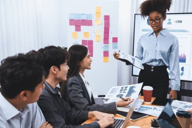 Genç Afrikalı iş kadını modern toplantıda TV ekranında veri analizi paneli sunuyor. Bir grup iş adamıyla konferans odasında iş sunumu. Uyum