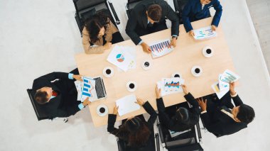 İş adamları grup toplantısı ofiste yukarıdan çekildi. İş kadınları, iş adamları ve ofis çalışanları toplantı masasında proje planlama belgeleriyle takım konferansında çalışıyorlar. Jivy