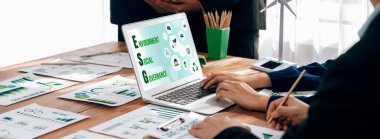 ESG 'nin çevresel sosyal yönetimi, çevre dostu şirket toplantılarında, temiz ve sürdürülebilir gelecekteki ekoloji için çevre korumasını uygulayan iş adamlarıyla dizüstü bilgisayarda sergileniyor. Önde.