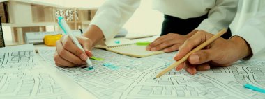 İşçi, mimar ve mühendis şehir alanının haritası ve kadastro haritası ile şehir planının inşaat geliştirici iş planına rehberlik etmek için emlak inşaatı hatiplik projesi hatiplik üzerinde çalışıyorlar.