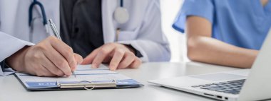 Hastane masasında birlikte çalışan ve tıbbi tedavi planlayan profesyonel tıbbi ekip. Takım çalışması başarılı hastalıklara ve hastalıklara yol açar. Panorama Katı