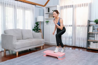 Enerjik bir kadın evde egzersiz yapıyor, kardiyo aerobik egzersizi yapıyor. Genç atletik Asyalı kadın mahareti ve dayanıklılık antrenmanı ev ödevi rutin konsepti olarak..