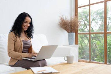 İnternette önemli bir iş için dizüstü bilgisayar kullanan Afro-Amerikalı bir kadın. Evde çalışan sekreter veya çevrimiçi içerik yazma.