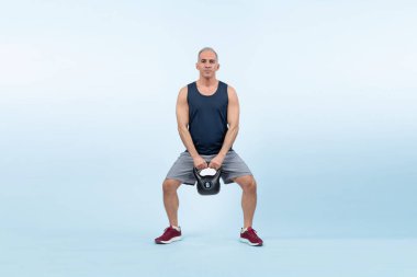Vücut uzunluğu tam, atletik ve sportif yaşlı bir adam izole edilmiş arka planda vücut çalışması için kettlebell ile hiçbir şey yapmıyor. Emeklilikten sonra sağlıklı, aktif bir fiziğe ve vücut bakımına sahip. Etki