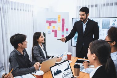 Pazarlama stratejisi için modern toplantıda veri analizi paneli ekranında sunan bir işadamı. Bir grup iş adamıyla konferans odasında iş sunumu. Uyum