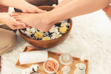 Kadınlar lüks spa salonlarında keyifli ayak masajlarına devam ederken, masör de hafif gün ışığı atmosferinde refleksoloji terapisi veya otel ayak spa 'sında. Sessiz.
