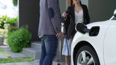 Elektrikli araç şarj istasyonu olan, sağlıklı ve temiz bir çevreyi teşvik eden yenilikçi bir aile kavramı. Sürdürülebilir, temiz enerji teknolojisiyle çalışan elektrikli araç..