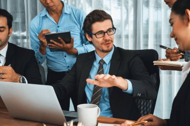 Modern ofis ortamında çalışan çeşitli etnik gruplardan çeşitli iş adamları. Üretken ve çok ırklı ofis çalışanları stratejik ticari pazarlama konusunda tartışmaya giriştiler. Habiliment