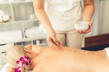 Lüks spa salonlarında sıcak mum ışığında cilt bakımı yaptıran kadın müşteri. Sağlık Spa vücut fırçasında tuz temizleme güzellik tedavisi. Sessiz.