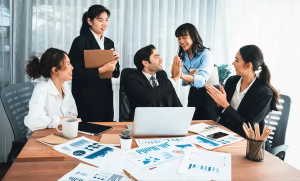 Group of happy businesspeople in high five gesture and successful efficient teamwork. Diverse race office worker celebrate after made progress on marketing planning in corporate office. Habiliment