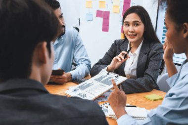 Çok ırklı analist ekibi toplantı masasındaki mali raporu analiz etmek için BI gösterge tablosunu kullanıyor. Çeşitli iş adamlarından oluşan bir grup, iş pazarlama kararı için FIntech 'in veri analizini kullanır. Uyum